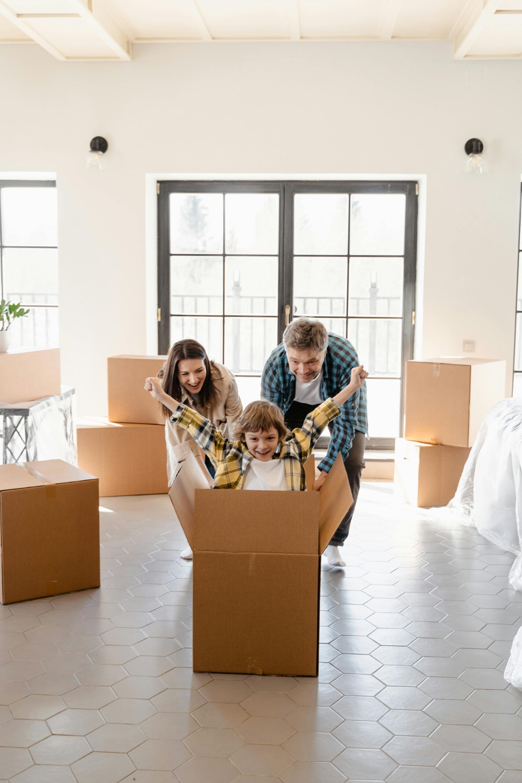 Happy family celebrating move into new home with unpacked boxes.